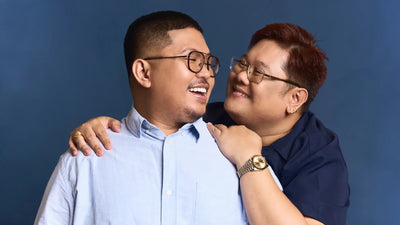 Two people embracing each other against a blue background
