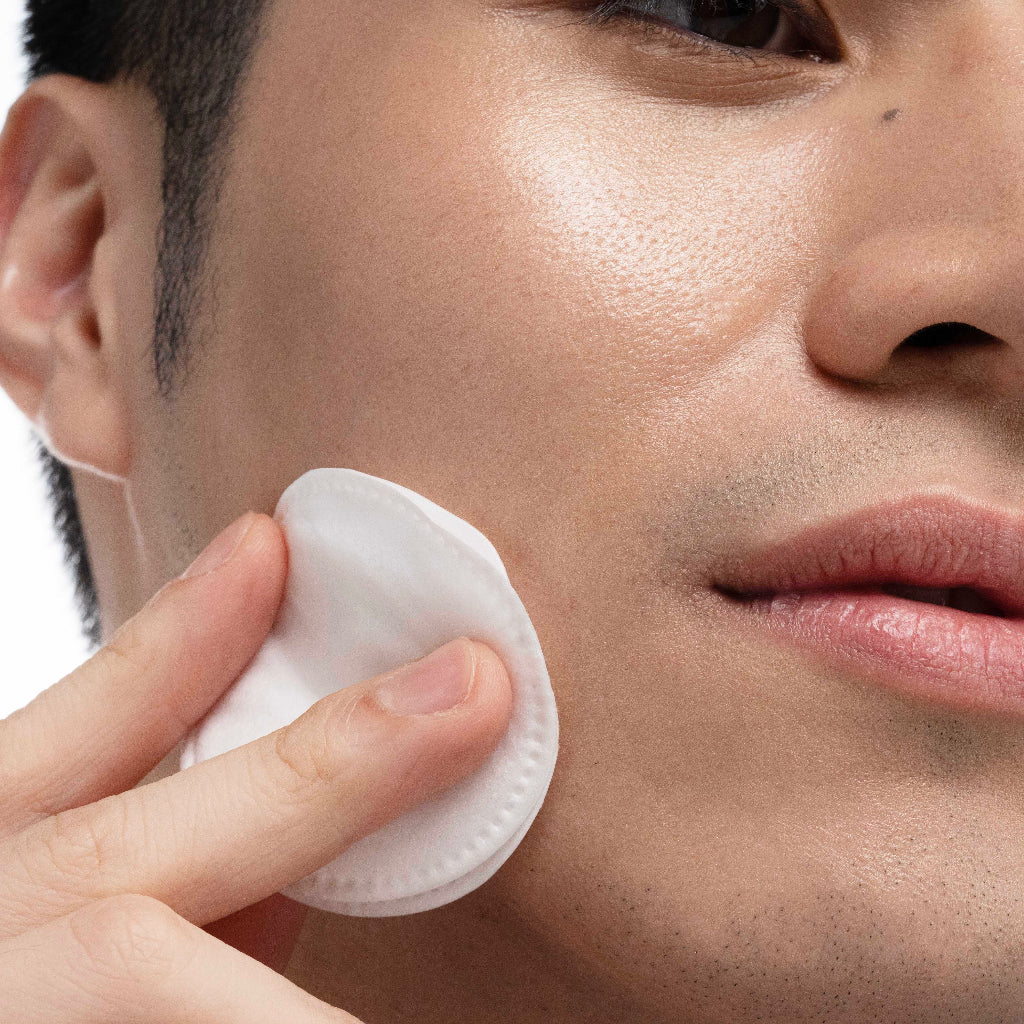 Person using a white silicone pad on their face