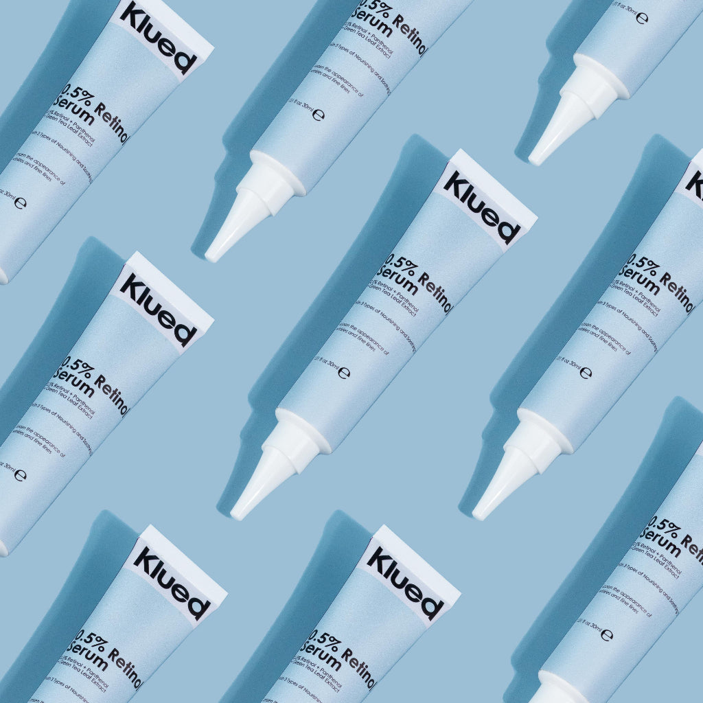 Pattern of Klued 3.5% Retinol serum tubes on a blue background