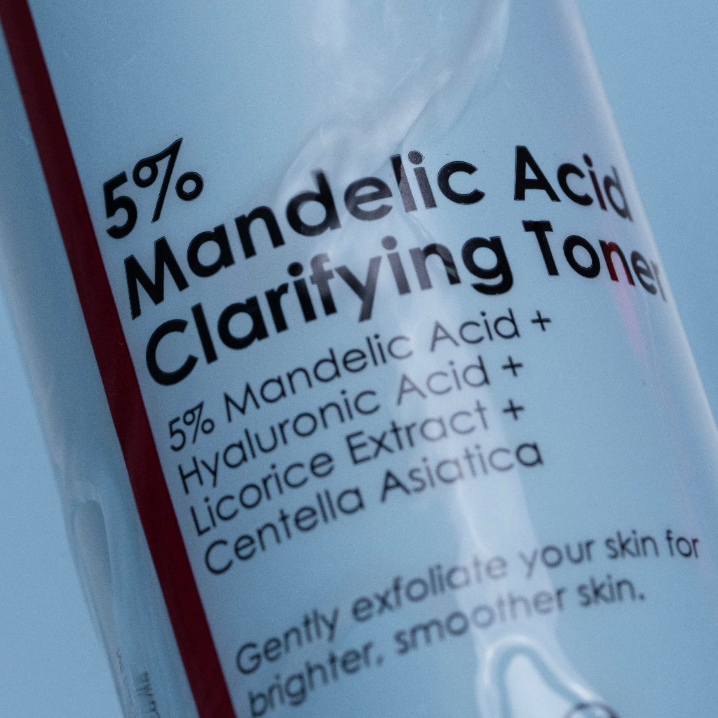 Bottle of 5% Mandelic Acid Clarifying Toner with text on a blue background