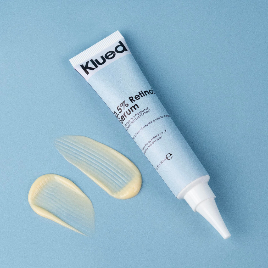 Klued 0.5% Retinol Serum tube with a swatch on a blue background