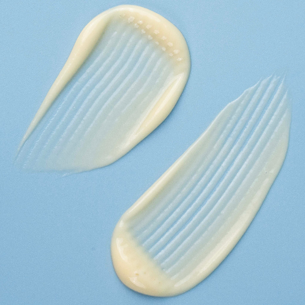 Two smears of a white cream-like substance on a blue background