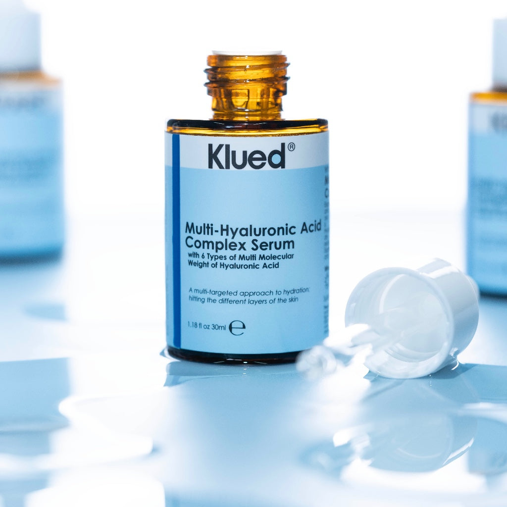 Klued Multi-Hyaluronic Acid Complex Serum bottle on a reflective surface with a blue gradient background