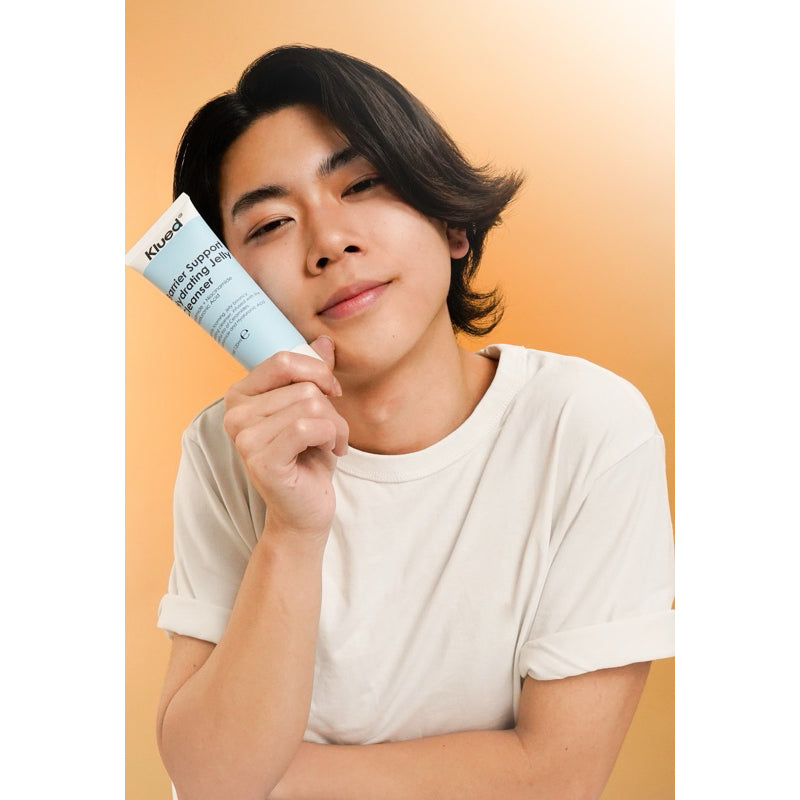 Person holding a Kiehl's skincare product against a beige background