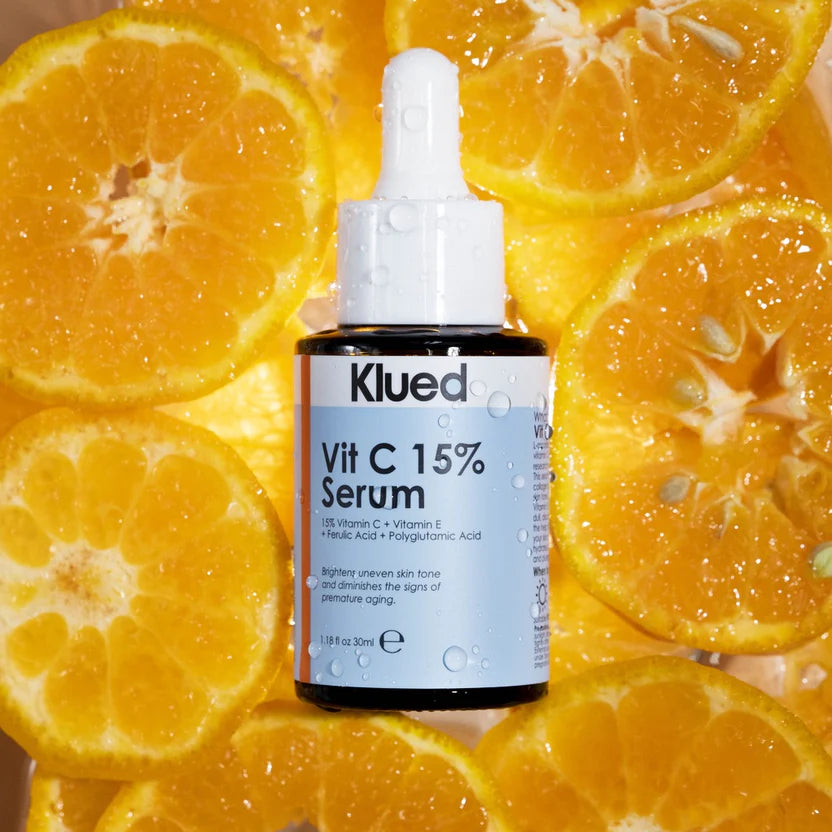 Klued Vit C 15% Serum bottle with sliced oranges in the background