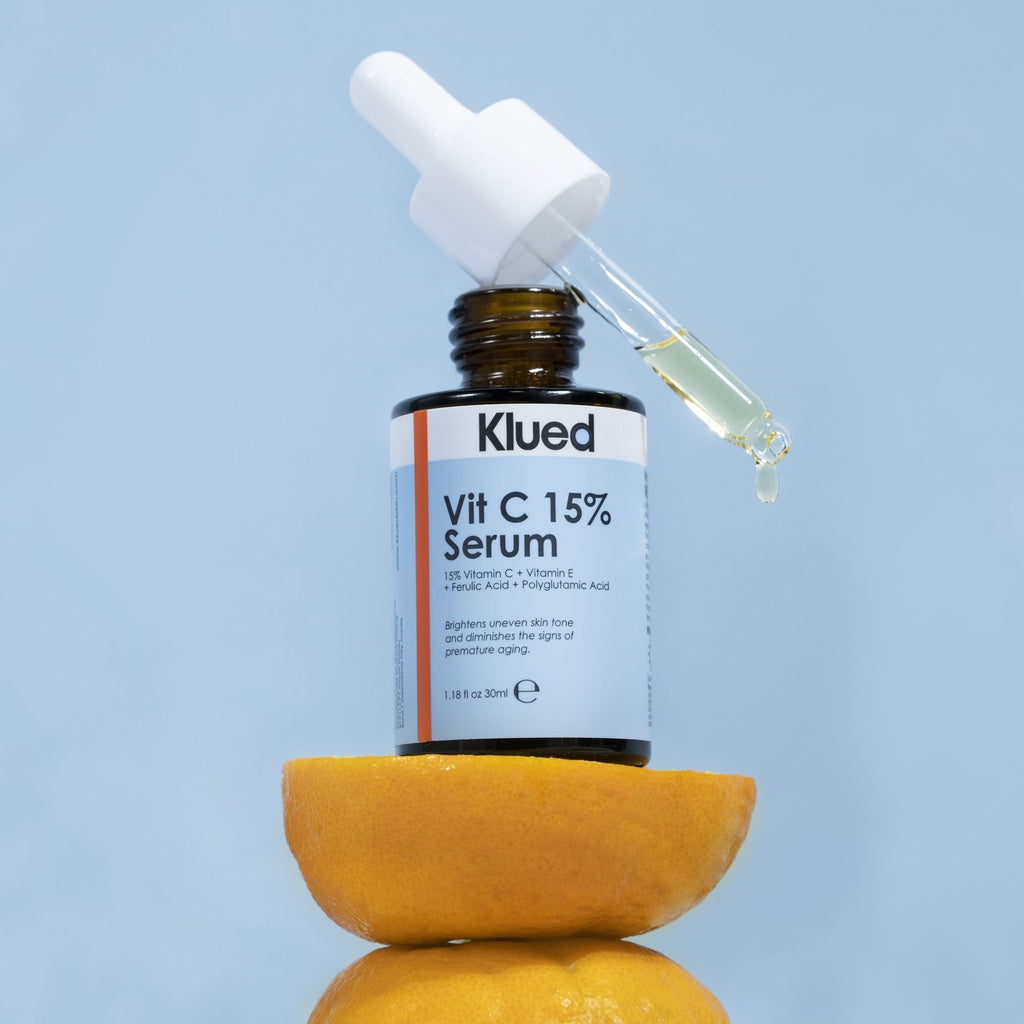 Klued Vit C 15% Serum bottle with dropper on a blue background